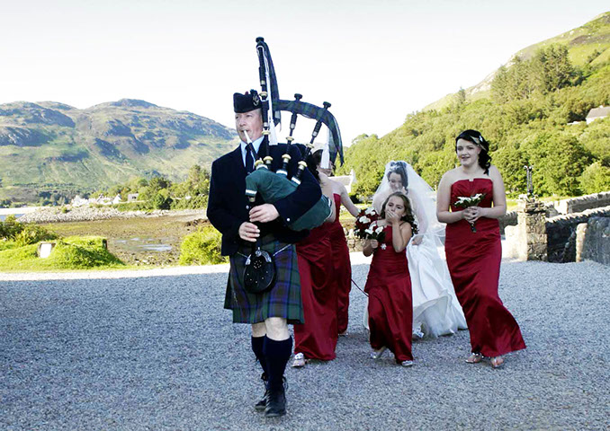 The Skye Piper playing at a wedding at Eiilan Donan Caste near the Isle of Skye